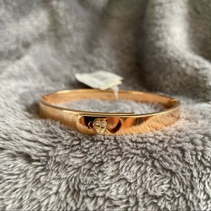 Gold-rose toned bangle with heart clasp.